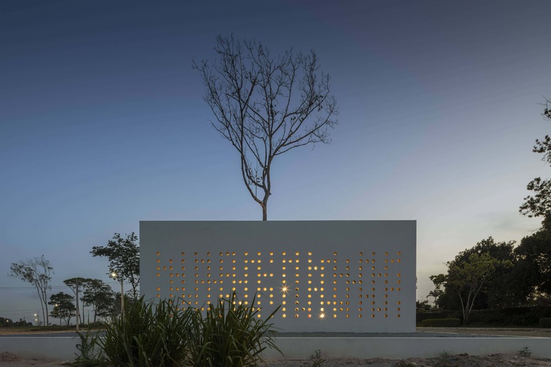 white perforated cubic facade wraps hybrid home and studio around a tree in brazil - 9