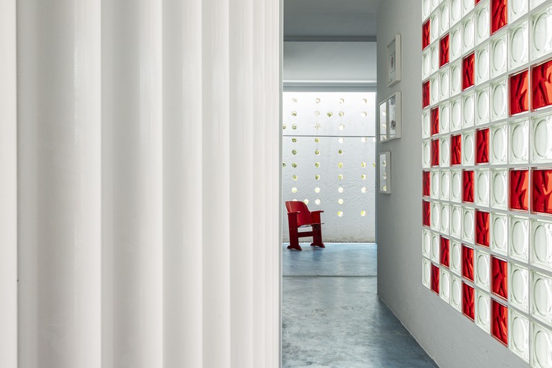 white perforated cubic facade wraps hybrid home and studio around a tree in brazil - 5