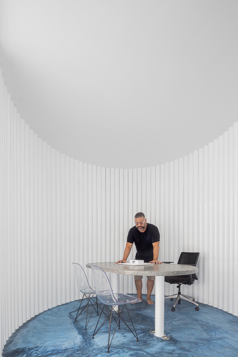 white perforated cubic facade wraps hybrid home and studio around a tree in brazil - 7