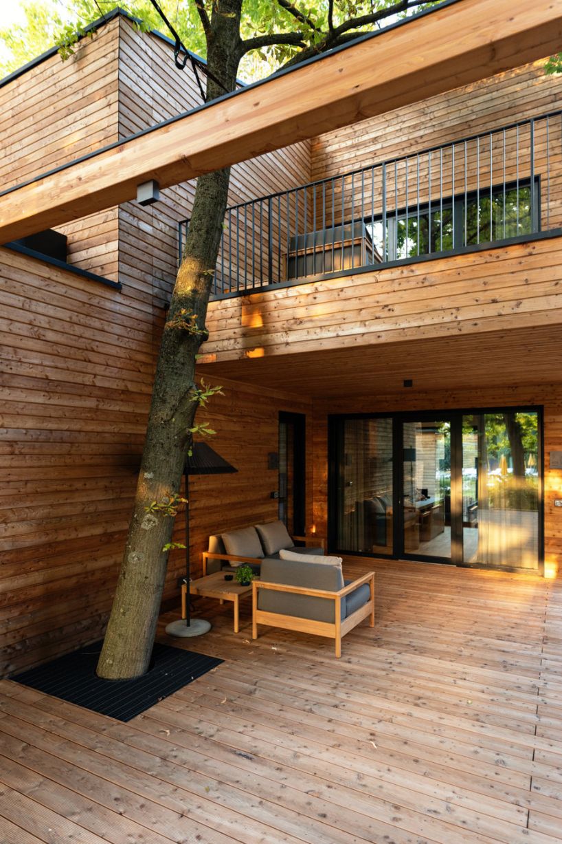 four wooden stilted structures host zero-emission resort's suites amongst centuries-old trees
