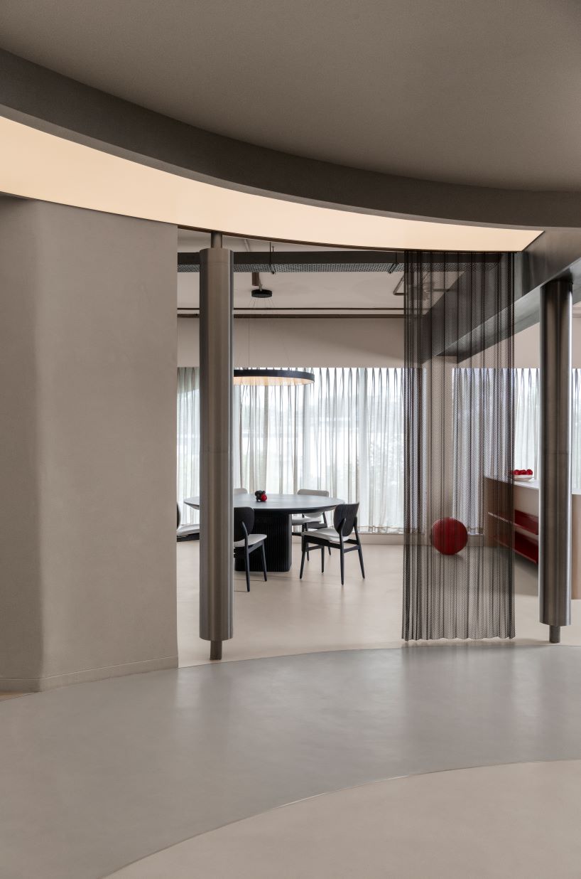 Sala de exposición de formas texturizadas de hormigón y acero en la India organizada en un ciclo continuo