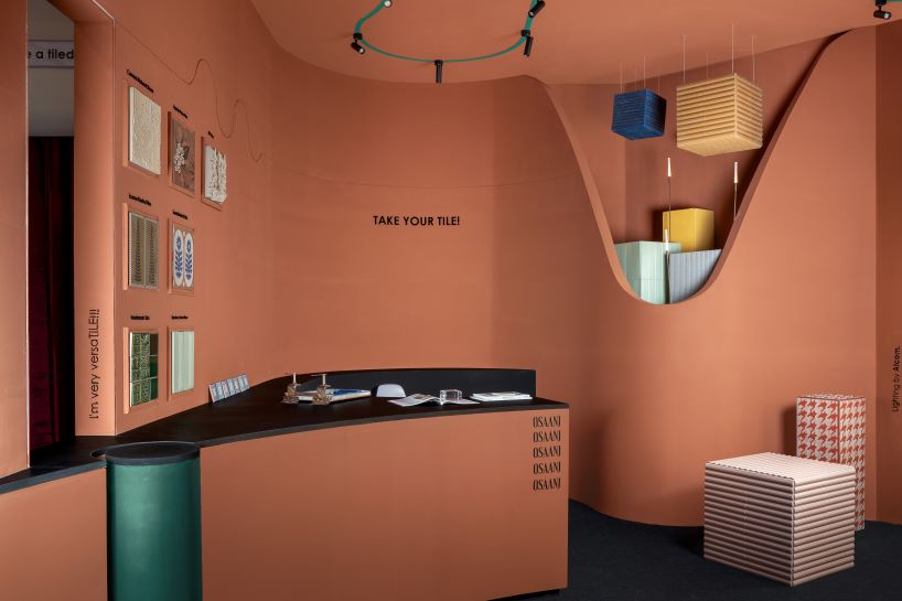 patterned tiles extend from curved walls to furniture in layered retail exhibition booth