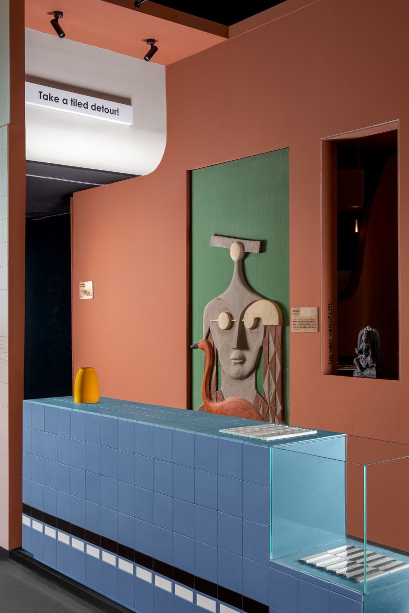 patterned tiles extend from curved walls to furniture in layered retail exhibition booth