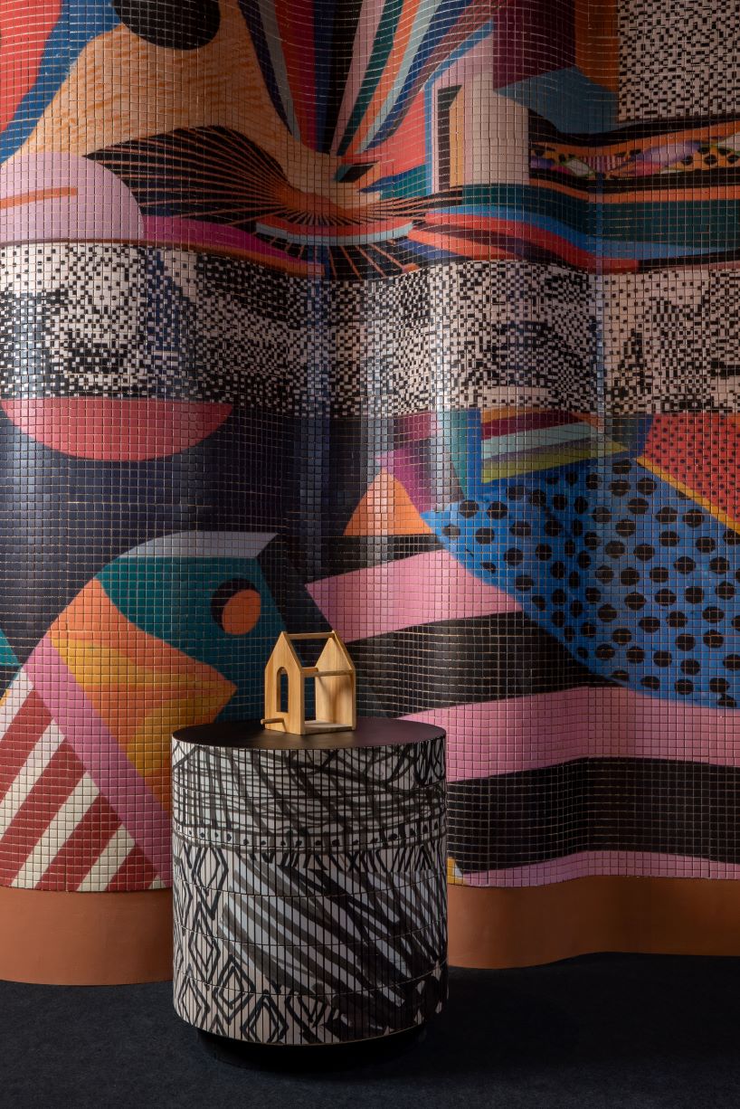 patterned tiles extend from curved walls to furniture in layered retail exhibition booth