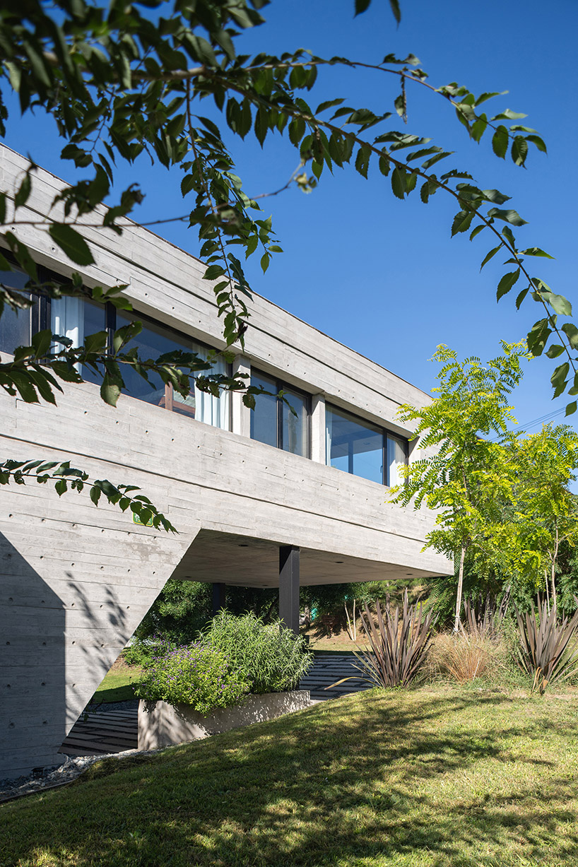 casa tres' exposed concrete volume by estudio galera floats above steep slope in argentina