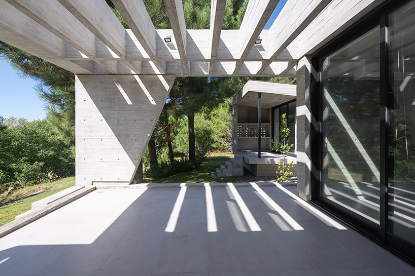 casa tres' exposed concrete volume by estudio galera floats above steep slope in argentina