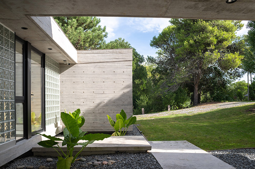 casa tres' exposed concrete volume by estudio galera floats above steep slope in argentina