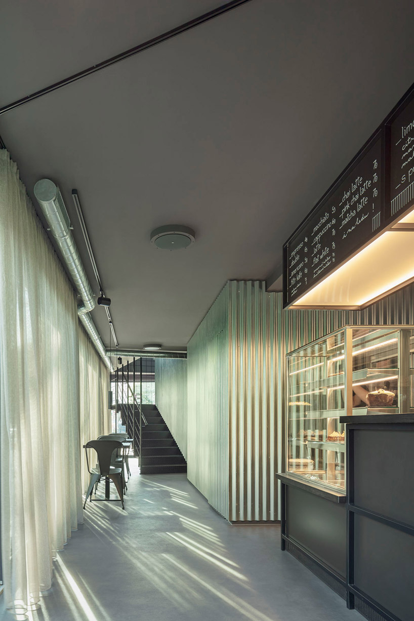 COLLARCH shapes café from gray recycled shipping containers in prague