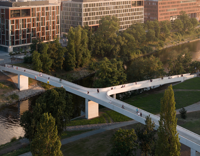 sleek concrete pedestrian bridge spans the vltava river in prague