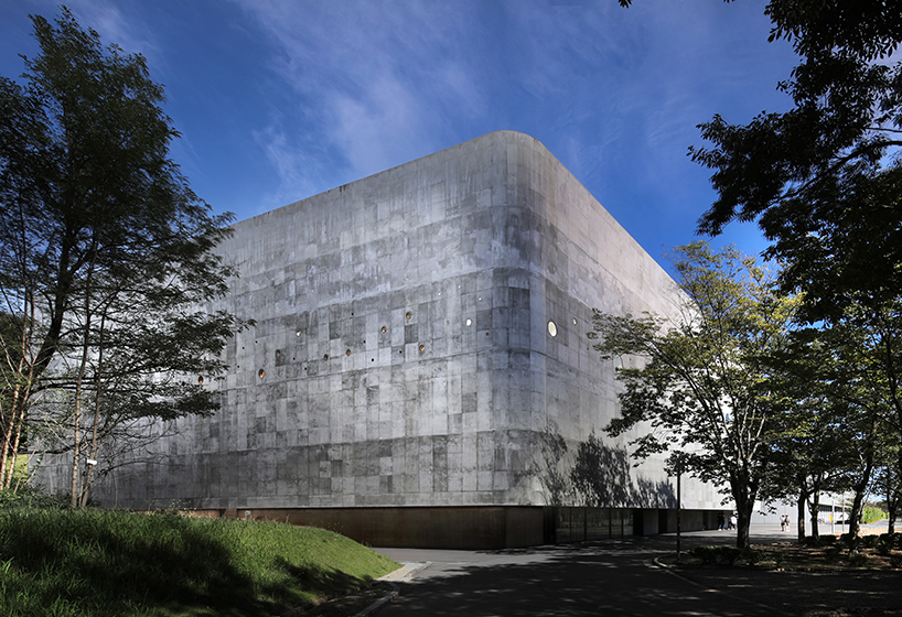 small and large holes peek through brutalist high school gymnasium in japan