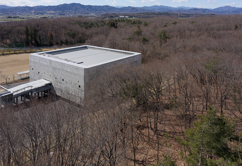 small and large holes peek through brutalist high school gymnasium in japan