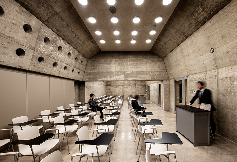 small and large holes peek through brutalist high school gymnasium in japan