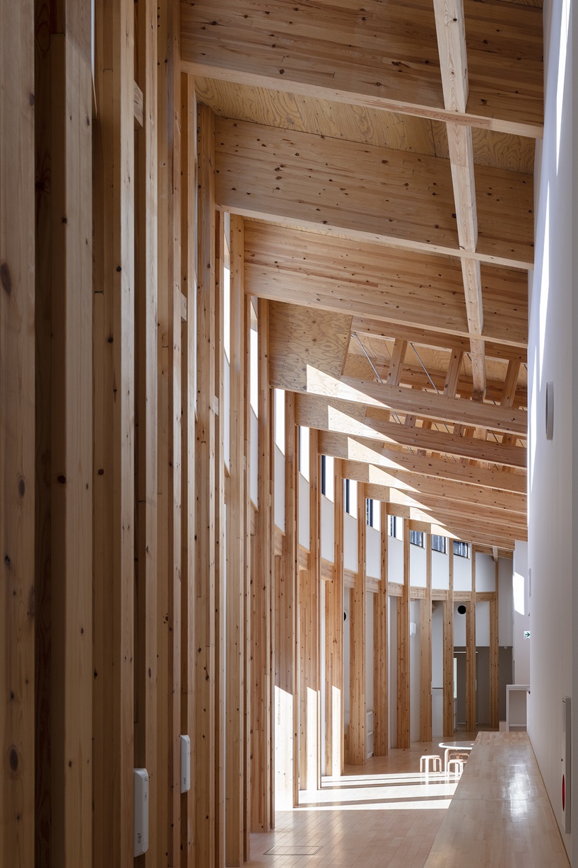 twin leaf-shaped roofs unfold atop nursery school by NIKKEN SEKKEI in japan