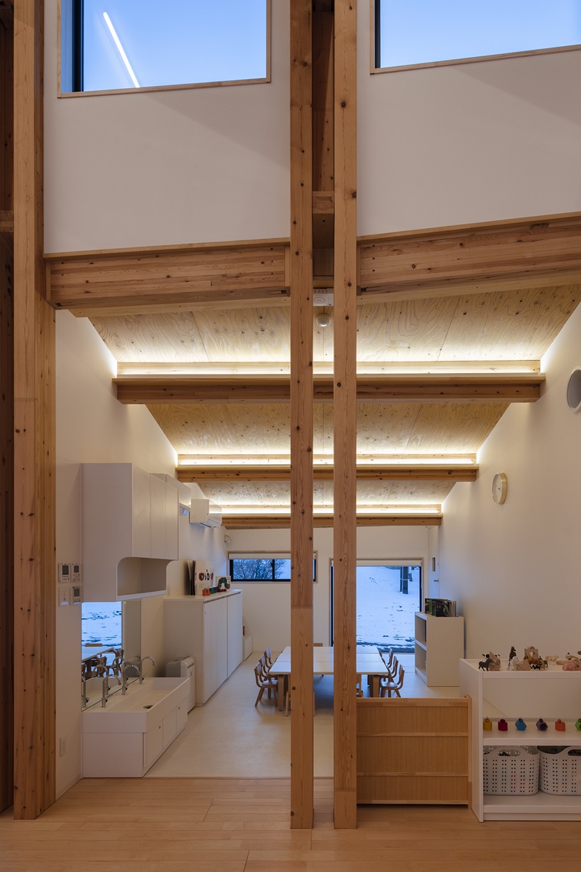 twin leaf-shaped roofs unfold atop nursery school by NIKKEN SEKKEI in japan