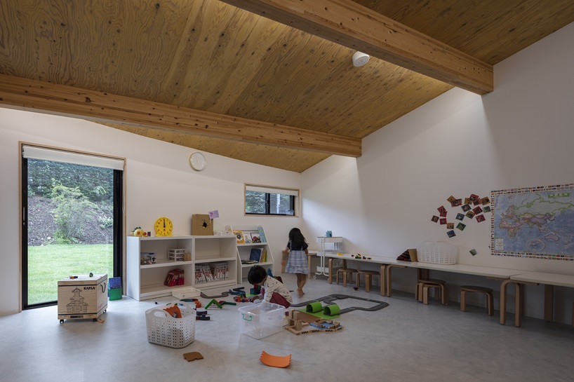 twin leaf-shaped roofs unfold atop nursery school by NIKKEN SEKKEI in japan