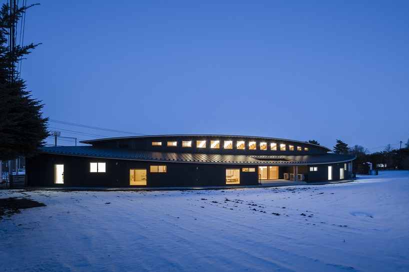 twin leaf-shaped roofs unfold atop nursery school by NIKKEN SEKKEI in japan