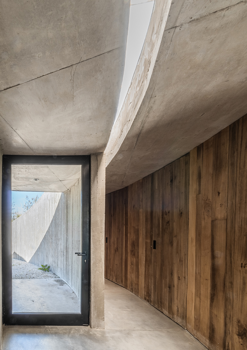 undulating walls emerge from ground to encircle atelierM's shire residence