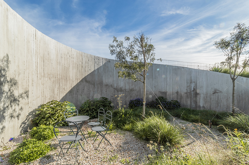 undulating walls emerge from ground to encircle atelierM's shire residence