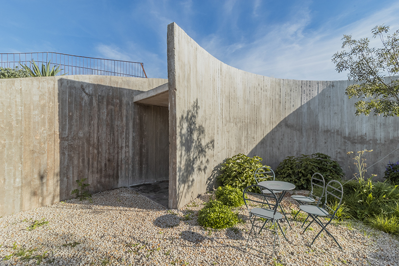 undulating walls emerge from ground to encircle atelierM's shire residence