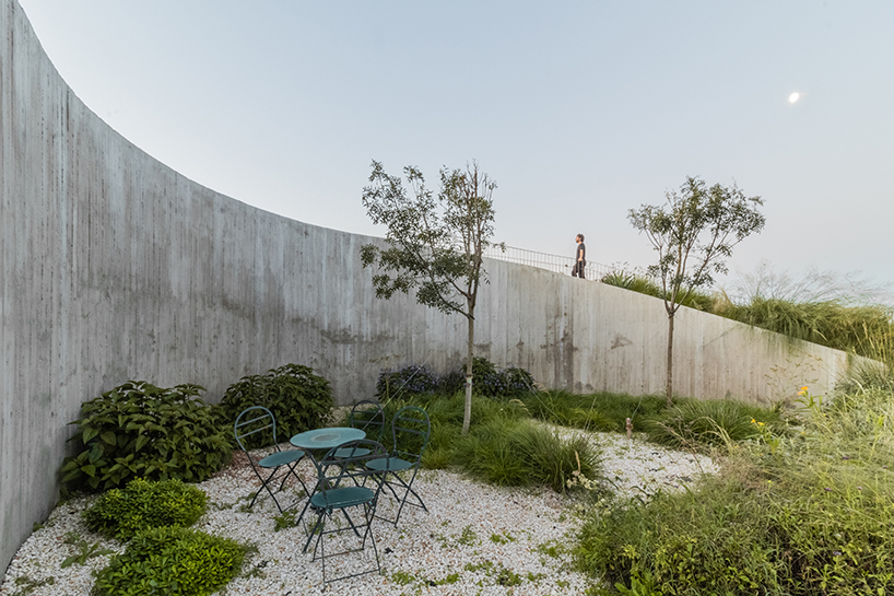 undulating walls emerge from ground to encircle atelierM's shire residence