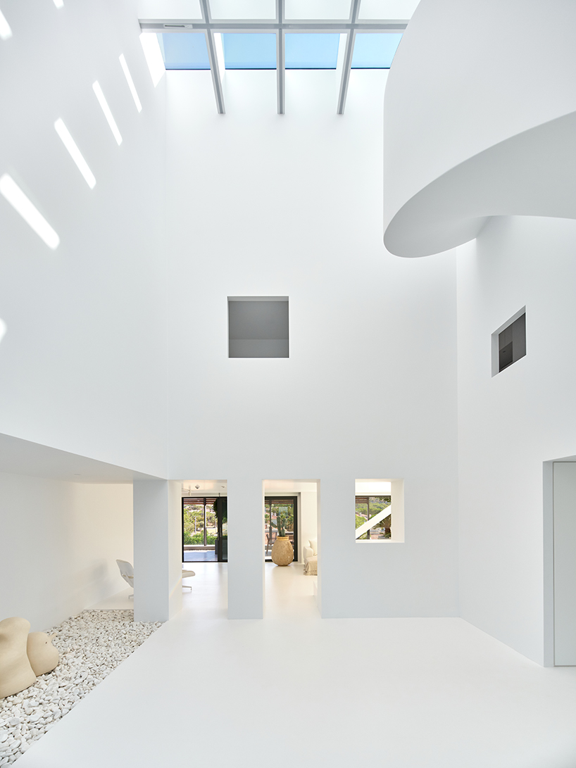 central spiral staircase rises up the atrium within residential project in turkey