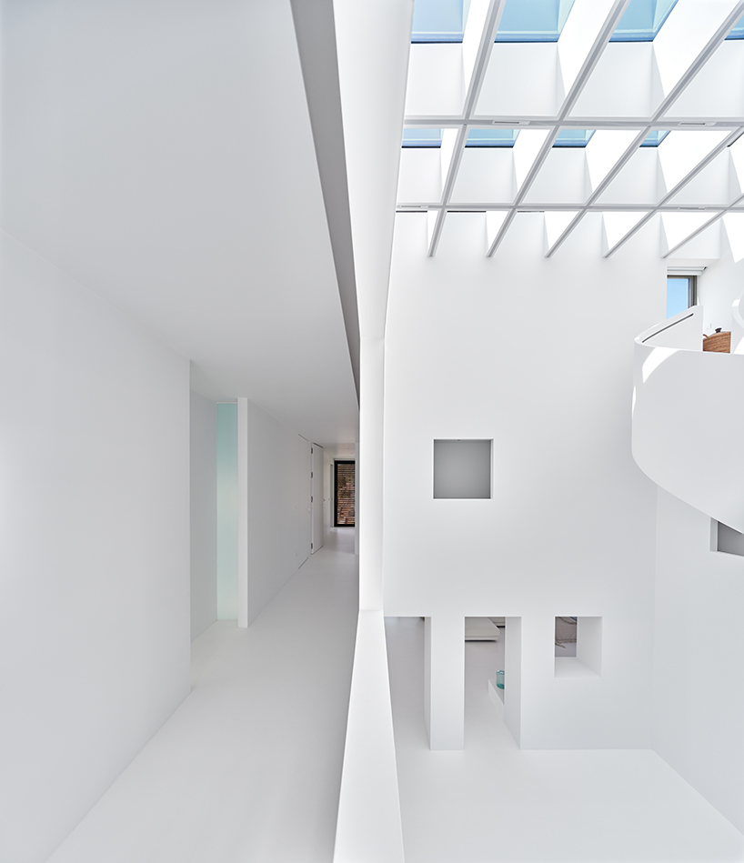 central spiral staircase rises up the atrium within residential project in turkey