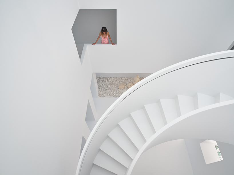 central spiral staircase rises up the atrium within residential project in turkey