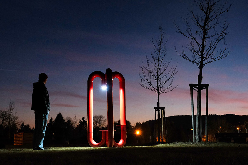 three-legged installation turns industrial gas pipes into intimate public shelter