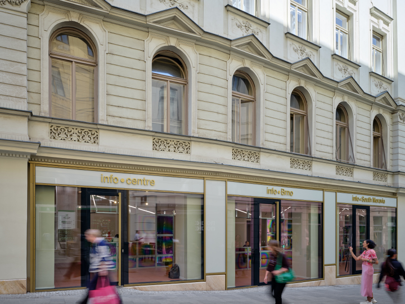 iridescent titanium panels cast chromatic reflections within info desk by KOGAA in brno