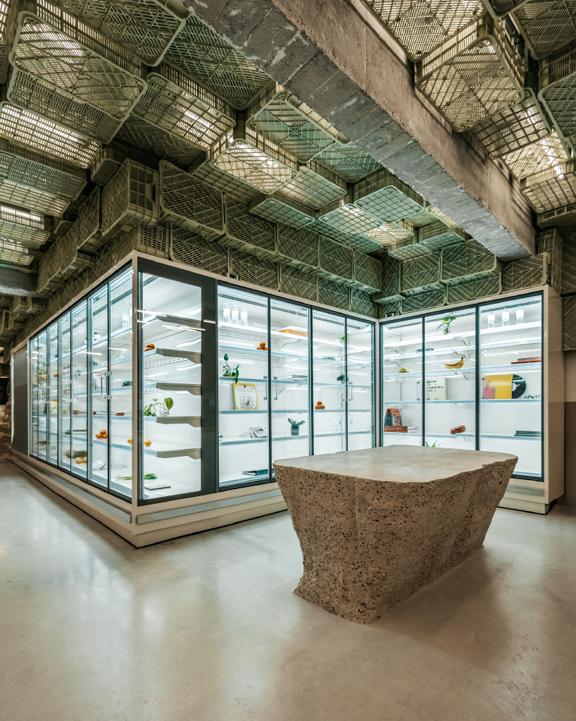 ceiling of recycled plastic crates expands over brutalist supermarket in mallorca