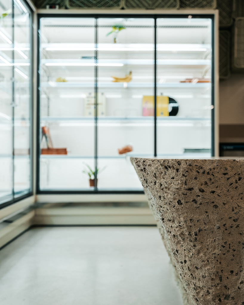 ceiling of recycled plastic crates expands over brutalist supermarket in mallorca