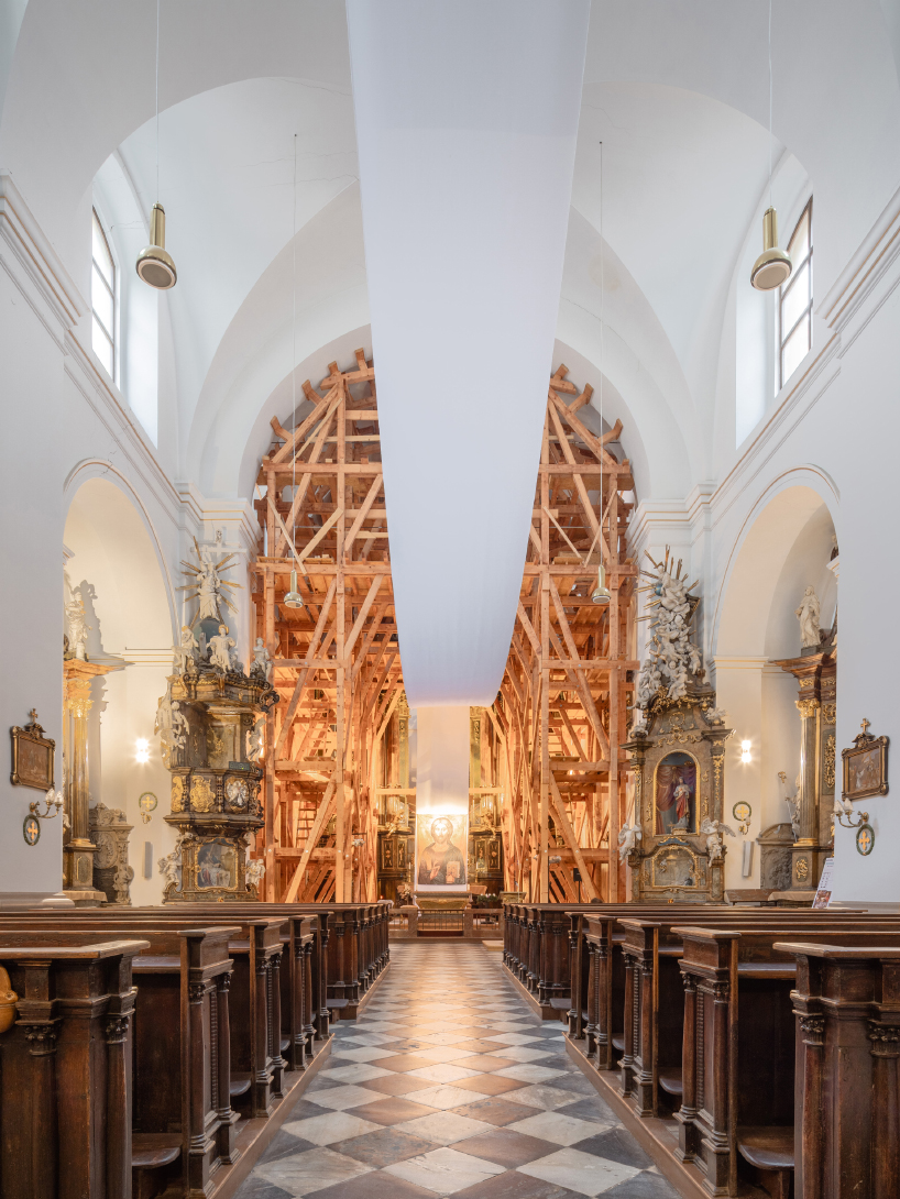 red and white curtains transform czech historic center’s pathways into christmas installation