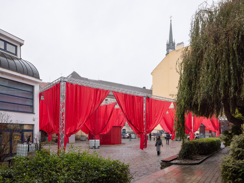 red and white curtains transform czech historic center’s pathways into christmas installation
