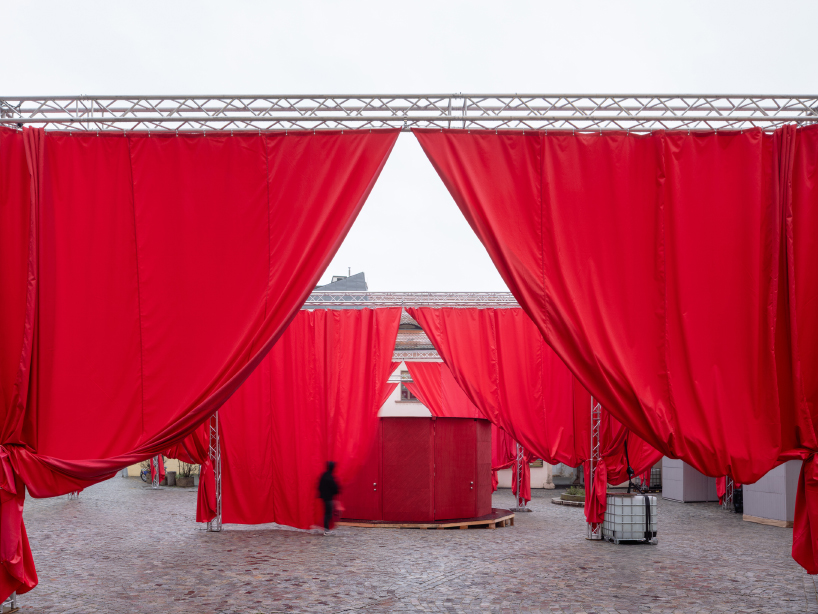 red and white curtains transform czech historic center’s pathways into christmas installation