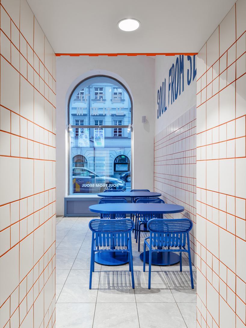 blue, red, and orange interiors bring seoul’s visual energy to the kimchi restaurant in prague - 10