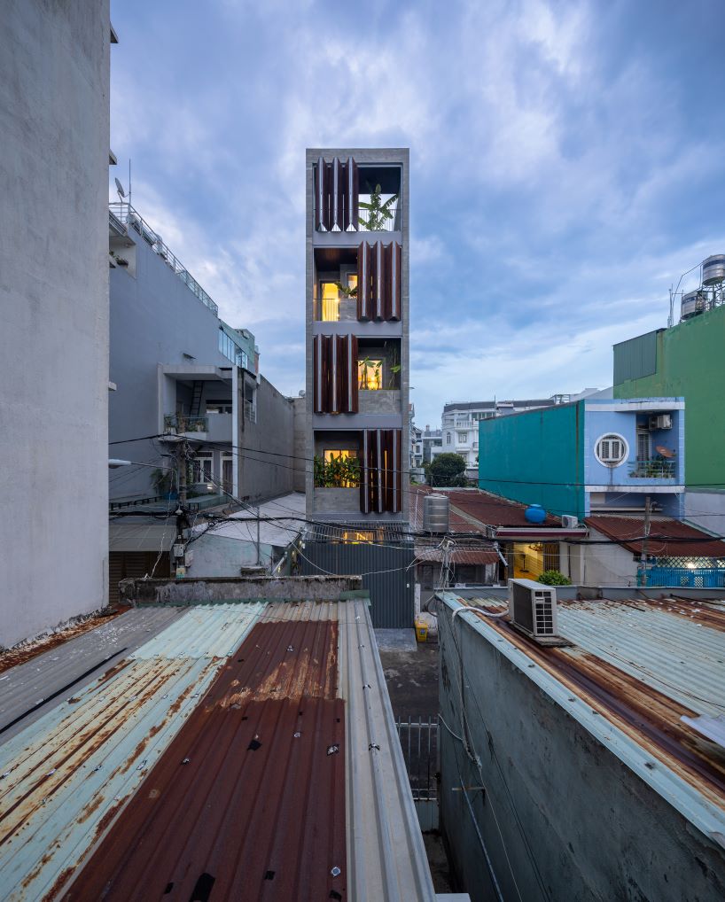 folding teak shutters weave light and nature into pham trung's narrow home in vietnam