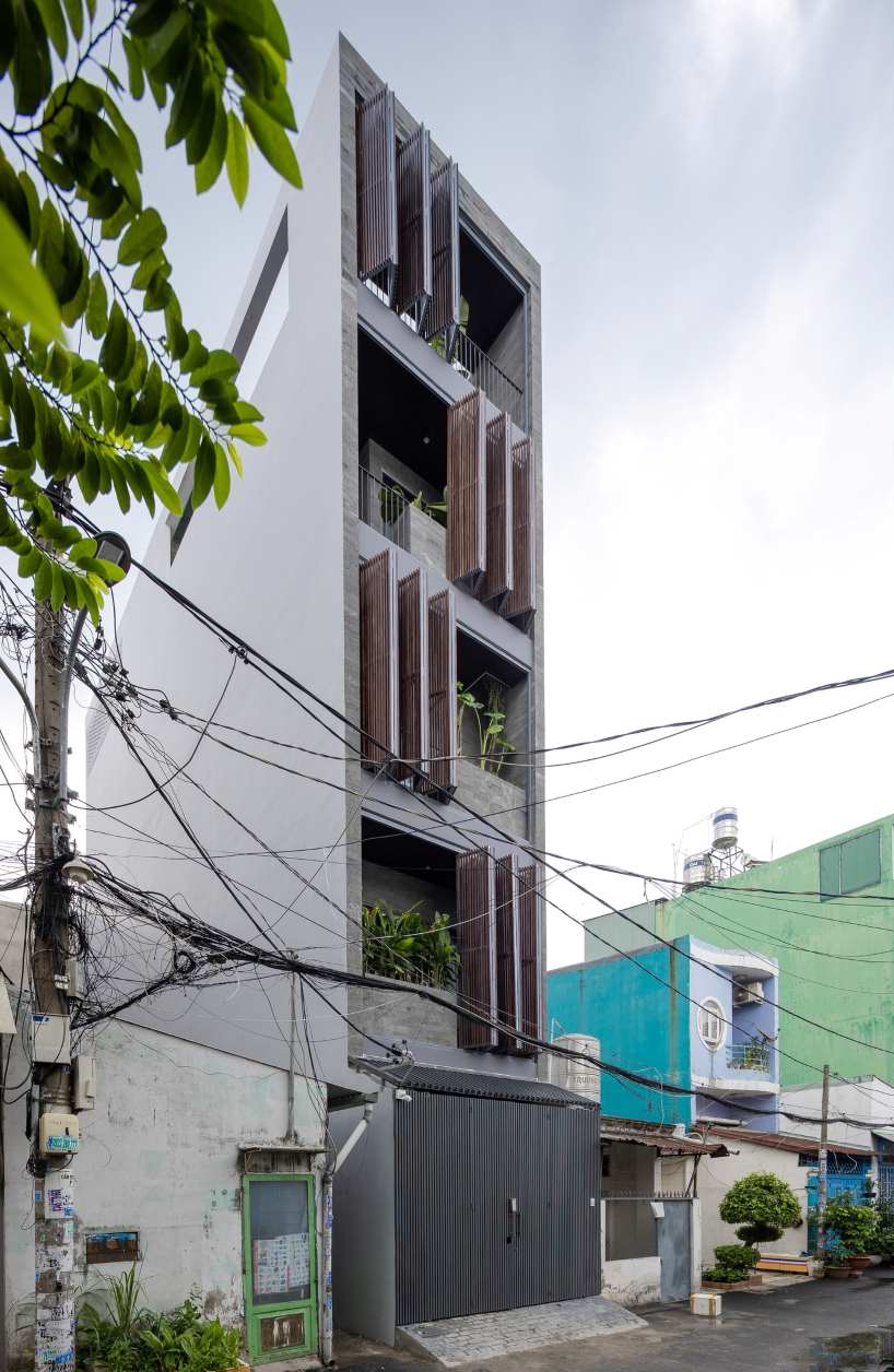 folding teak shutters envelop pham trung's narrow home in vietnam