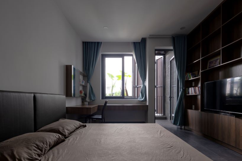 folding teak shutters weave light and nature into pham trung's narrow home in vietnam