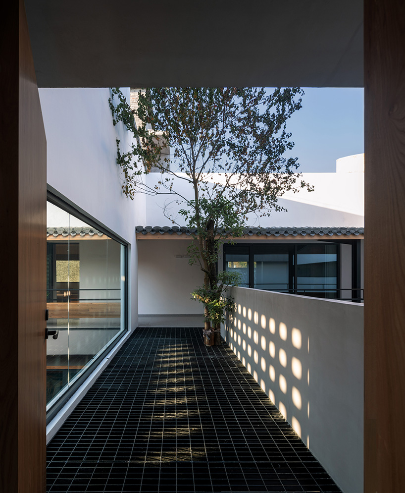 elongated gray brick cladding envelops hotel in chinese ancient village
