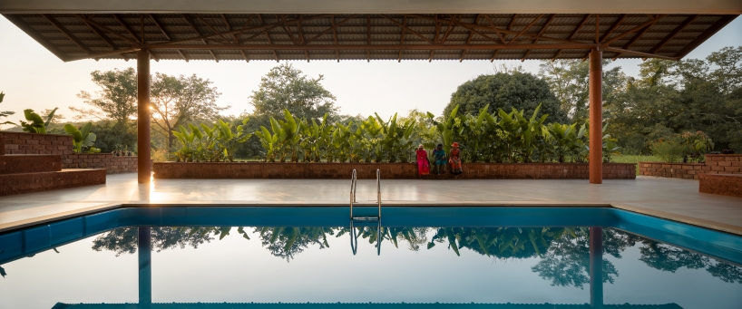 gabled roof floats over gathering pavilion’s brick stepped plinths in india - 7