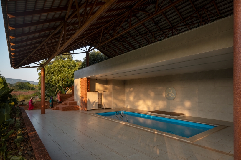 gabled roof floats over gathering pavilion’s brick stepped plinths in india - 8