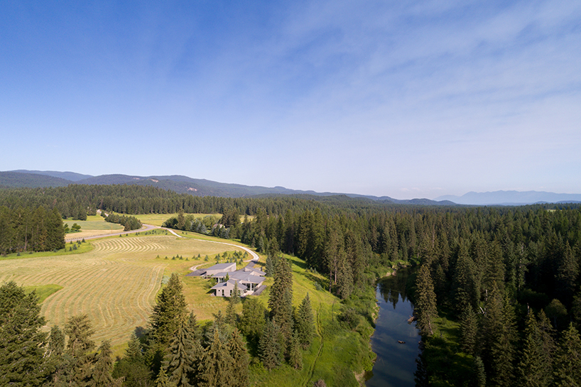 'stillwater residence' emerges as a series of farm sheds in the verdant veil of montana