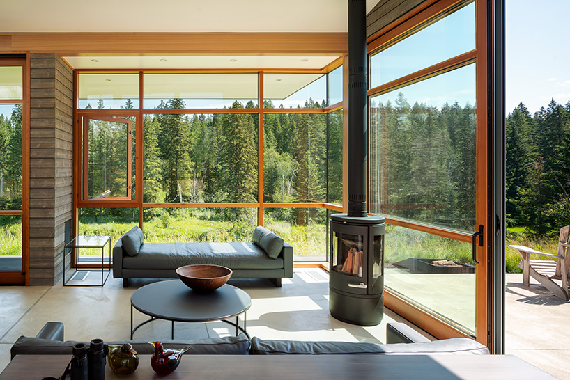 the stillwater residence emerges as a series of farm sheds in the verdant veil of montana