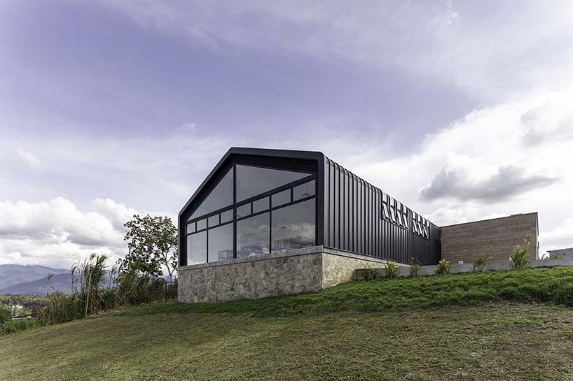 black metal sheets run along elongated volume of community dining space in ecuador