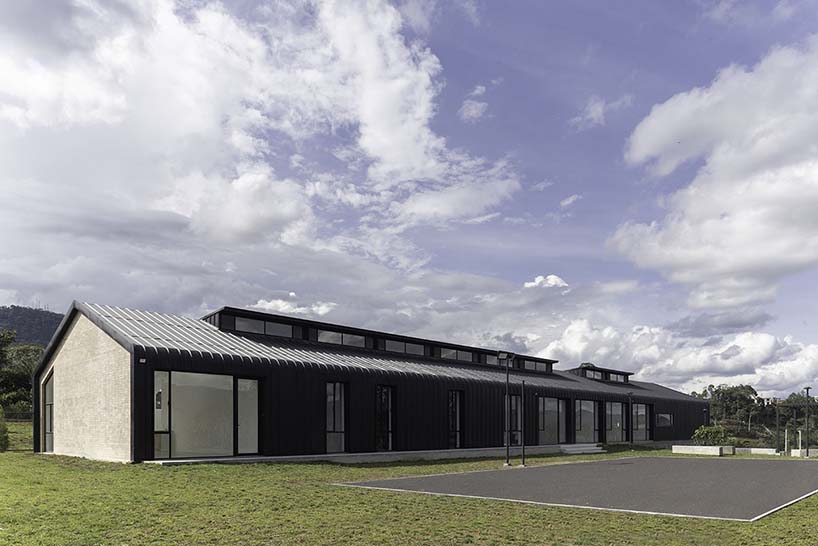 black metal sheets run along elongated volume of community dining space in ecuador