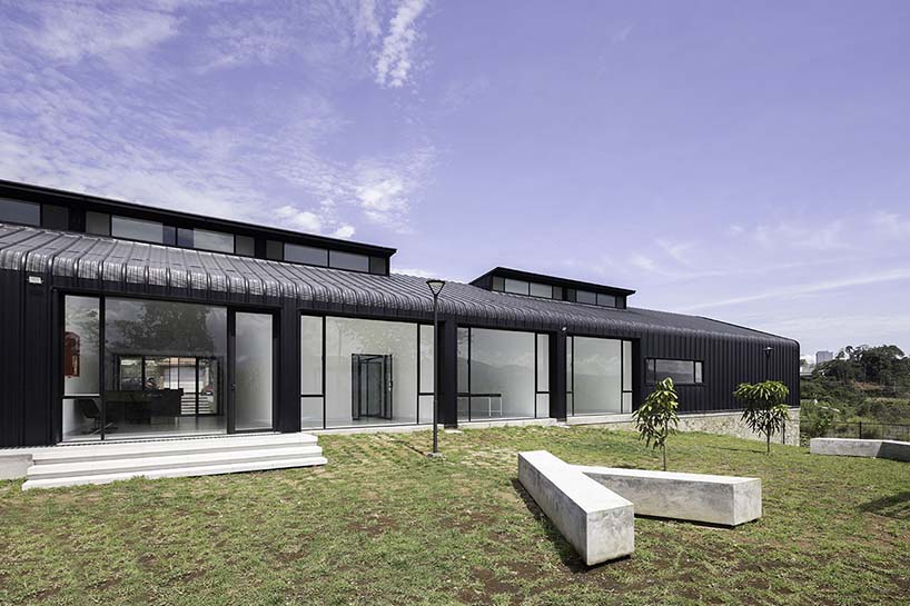 black metal sheets run along elongated volume of community dining space in ecuador