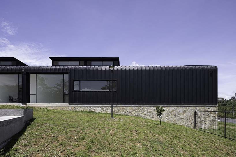 black metal sheets run along elongated volume of community dining space in ecuador