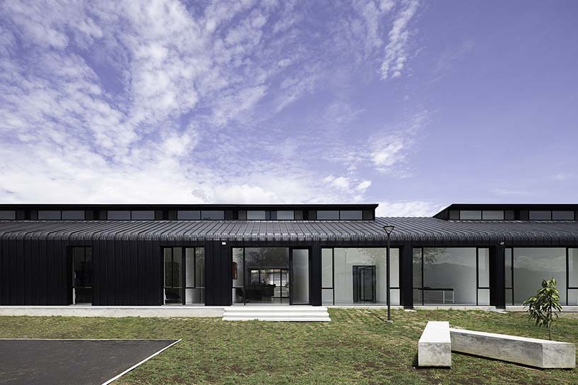 black metal sheets run along elongated volume of community dining space in ecuador