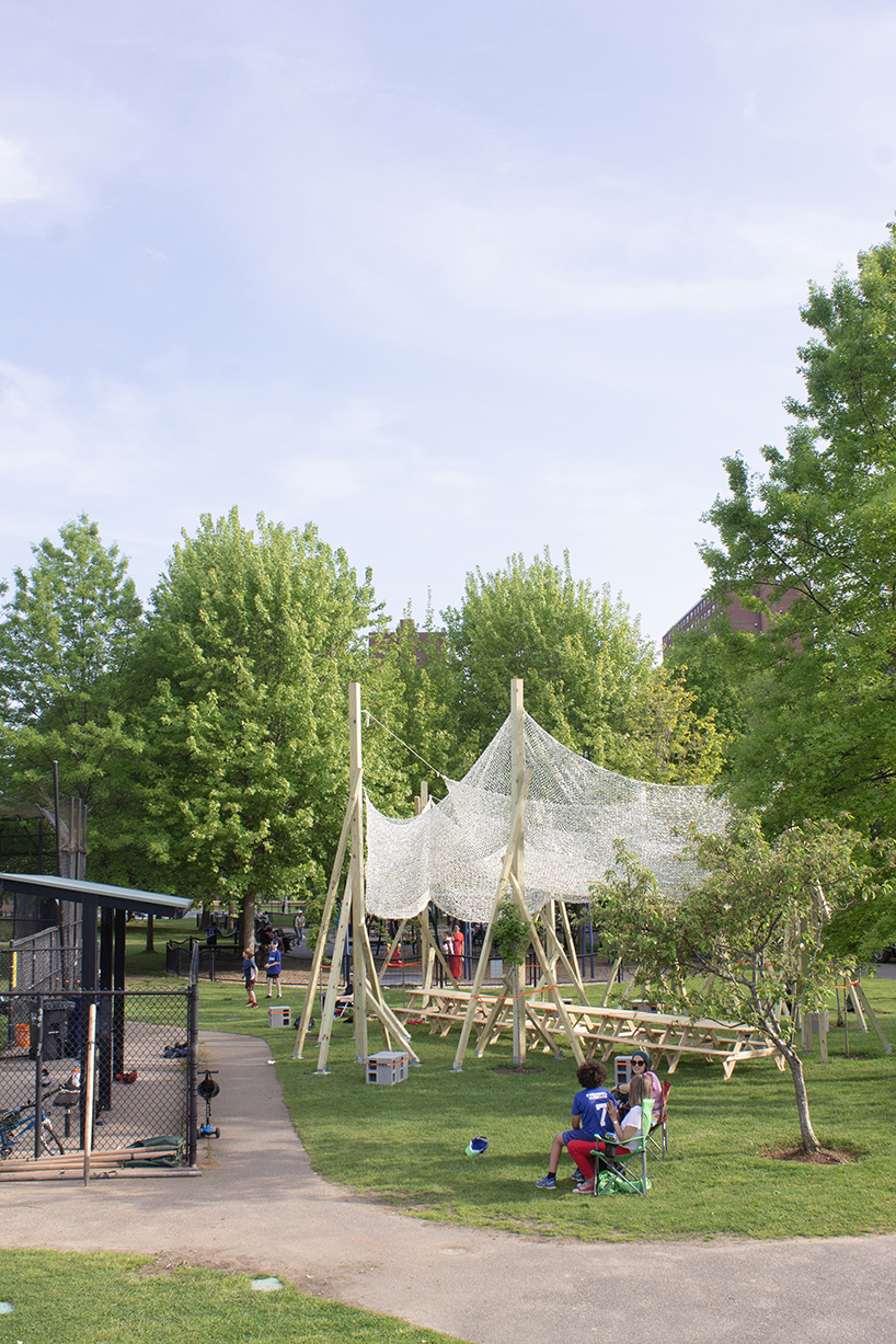 vanishing community room by alsar atelier uses tree stakes and textile canopies for shading