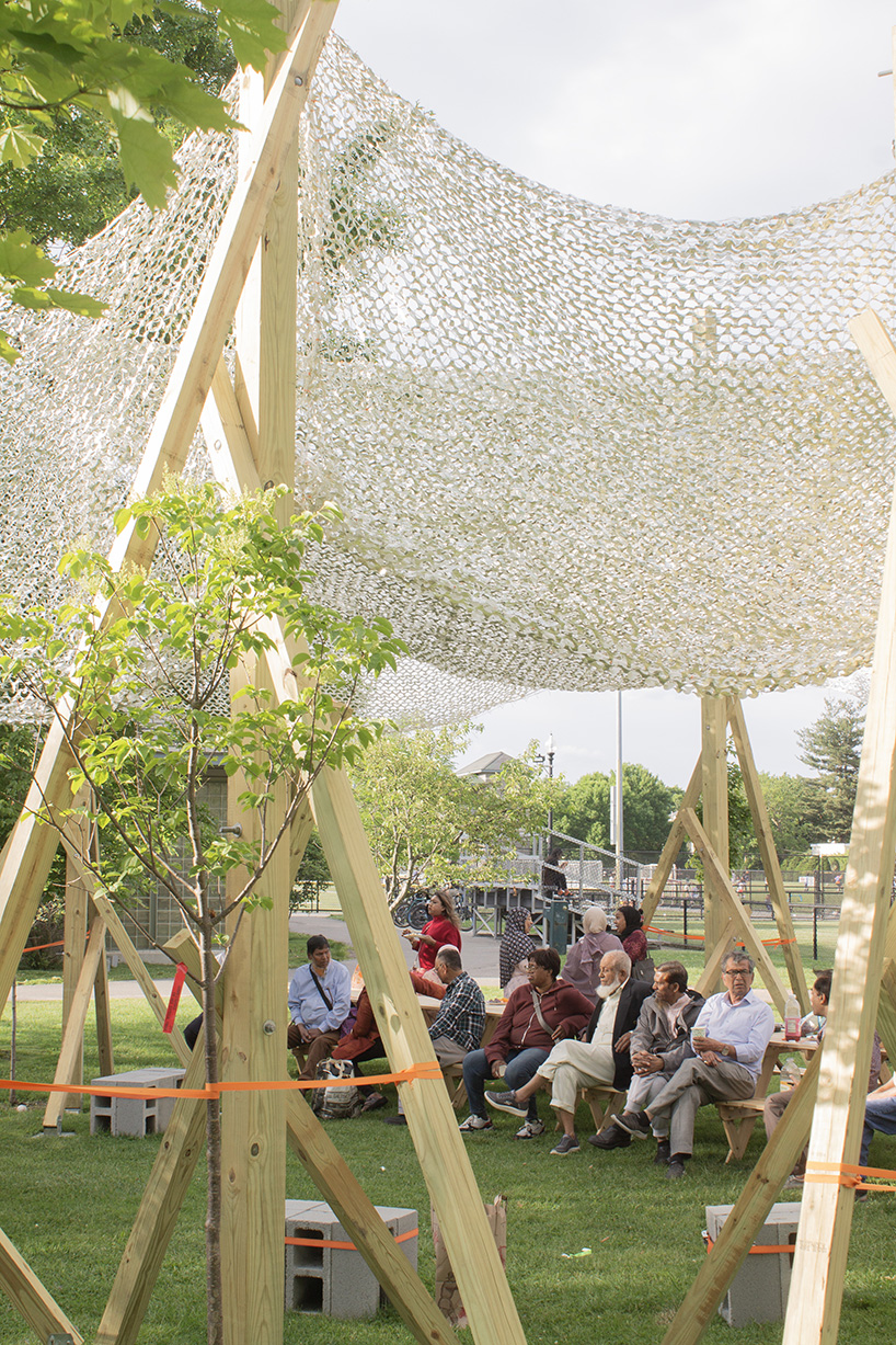 vanishing community room by alsar atelier uses tree stakes and textile canopies for shading